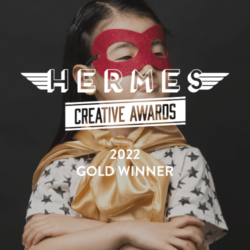 Hermes Creative Award logo overlayed over girl in cape (2x size)