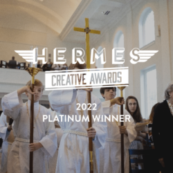 hermes creative award logo overlaying boys carrying crosses in church