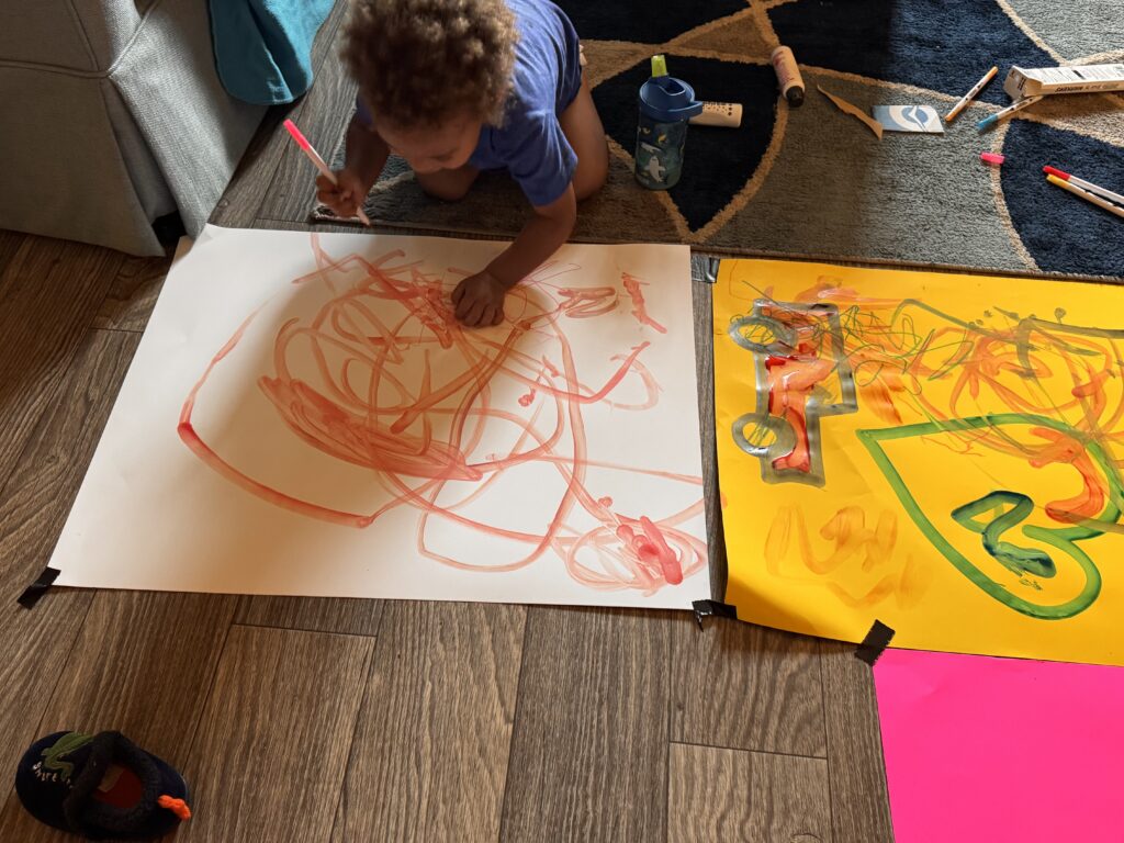 child coloring with a red marker
