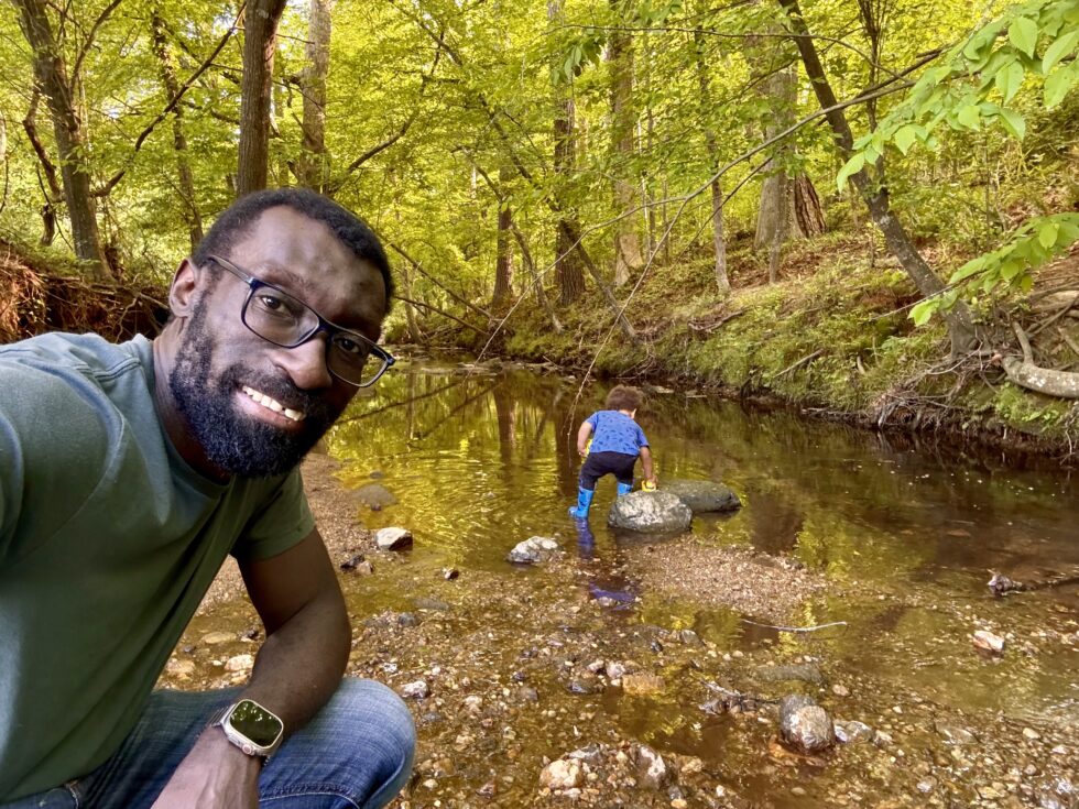 Musole next to a creek with his son